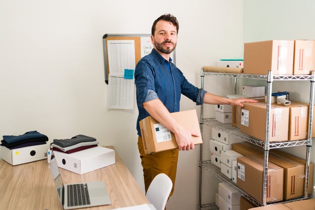 i-have-growing-business-portrait-handsome-entrepreneur-smiling-making-eye-contact-while-preparing-packages-ready-ship-customers